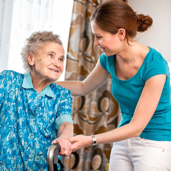Pflegerin stützt ältere Frau